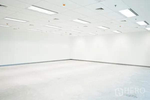 Office Space for rent in Bang Na, Bangkok - Empty office corner with white walls, ceiling vents and fluorescent lighting, ready for customization.