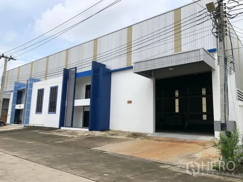Factory for rent or sale in Samut Prakan - Street view of contemporary factory units featuring dual loading entrances and parking apron.