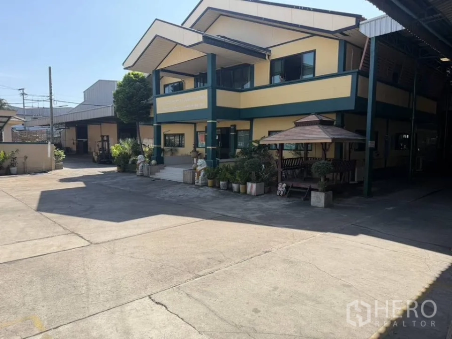 工厂 for rent in Bang Phli, Samut Prakan - 带绿色装饰线的办公楼与花园，旁有遮阳凉亭。
