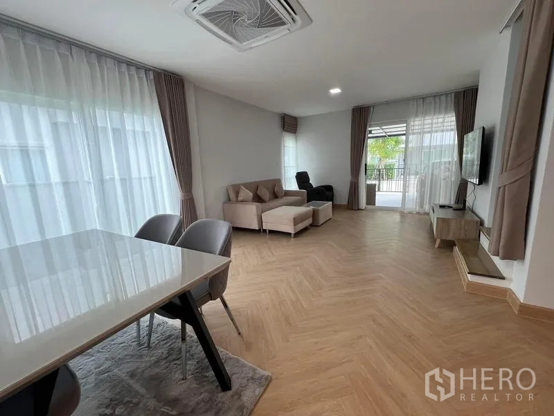 Detached House for rent in Bang Phli, Samut Prakan - Open-plan living and dining area with neutral decor and wide glazing to the terrace.