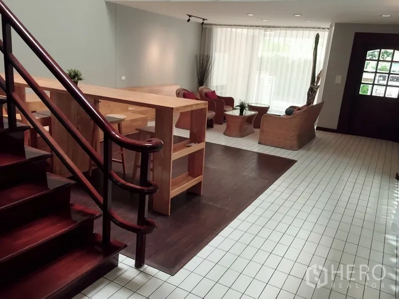 Townhouse for rent in Watthana, Bangkok - Open-plan lounge with breakfast bar, seating area and staircase.