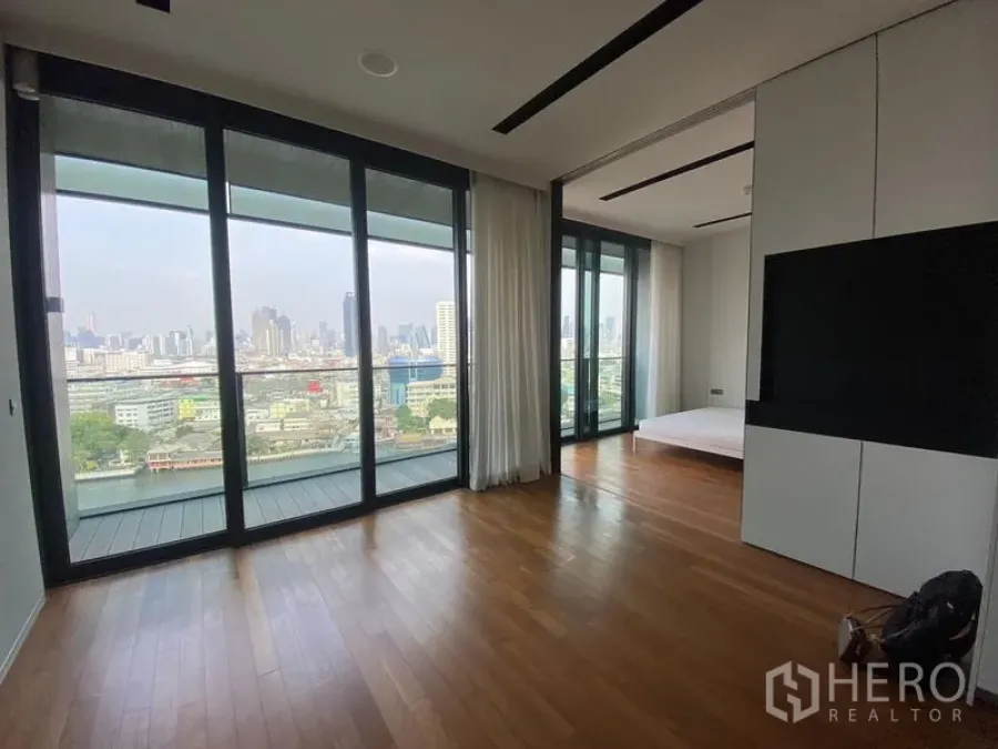 Condominium for rent - Bright lounge with panoramic river and skyline views through floor-to-ceiling windows.