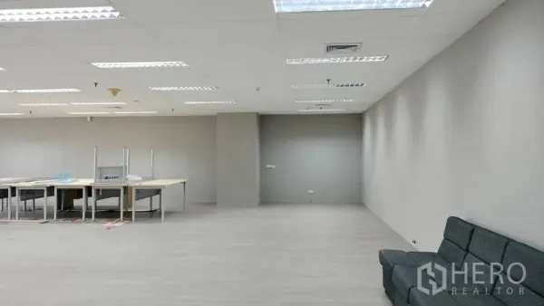 办公空间 出租或出售在Pathum Wan, Bangkok - 宽敞开放式办公区，灰色墙面、沙发与工位，LED照明。