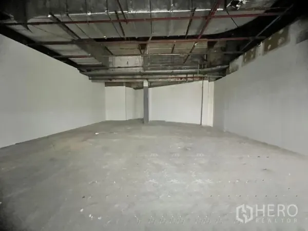Retail Space for rent in Khlong Toei, Bangkok - Spacious open-plan interior with exposed ductwork ceiling and unfinished concrete floor.