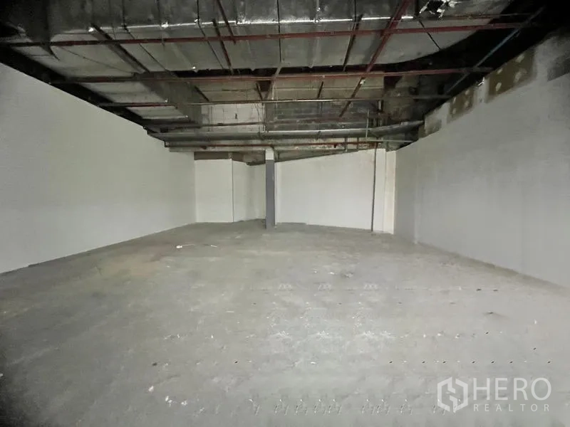 Retail Space for rent in Khlong Toei, Bangkok - Spacious open-plan interior with exposed ductwork ceiling and unfinished concrete floor.