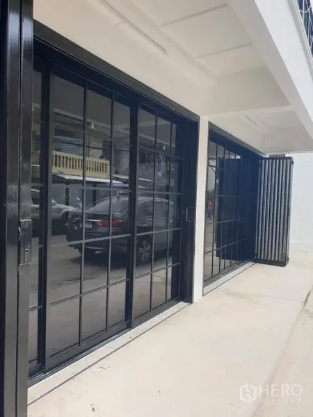 Home Office for rent or sale in Bang Na, Bangkok - Ground floor with black-framed sliding glass doors along the frontage.