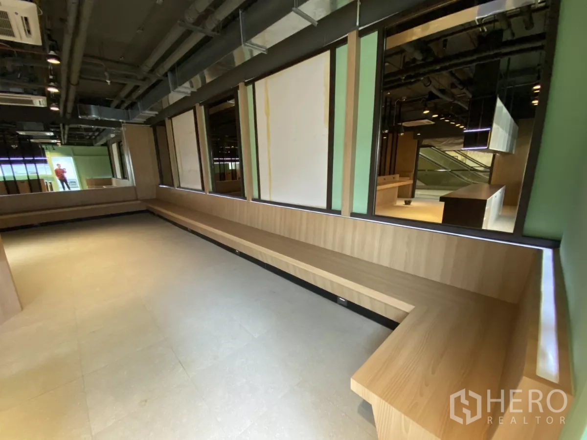 Retail Space for rent - L-shaped built-in bench seating along a mirrored wall inside the unit.
