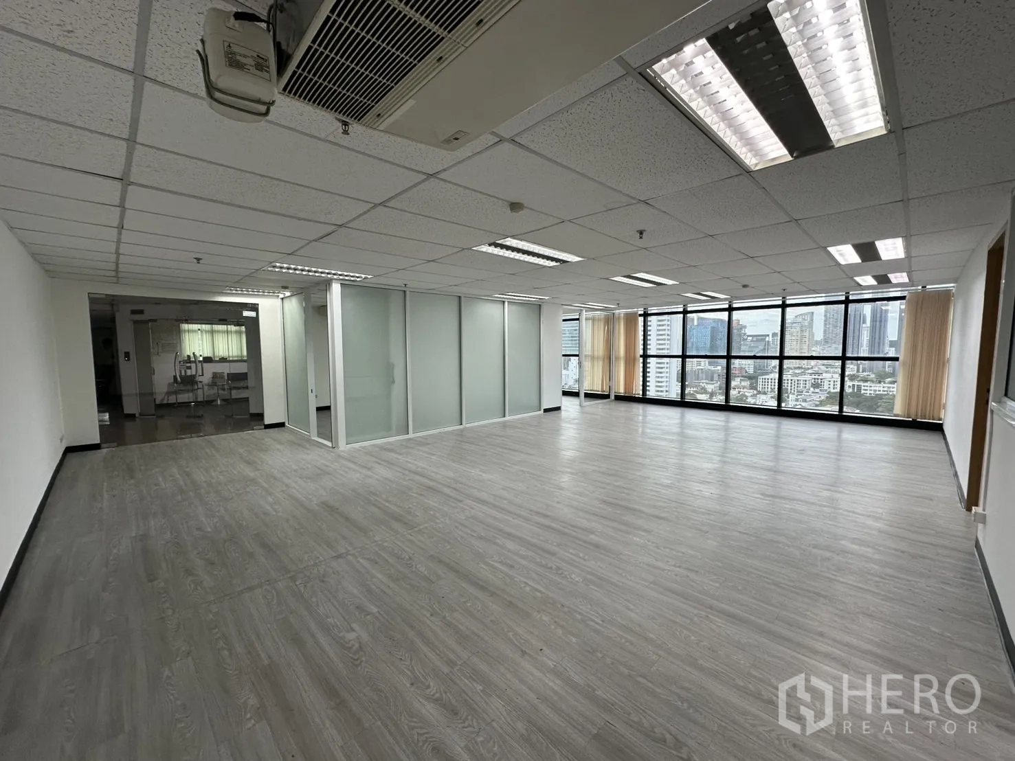Office Space for rent in Watthana, Bangkok - Open-plan 135 sqm office near BTS Ekkamai with split-type A/C, frosted-glass rooms and wide city-view windows.