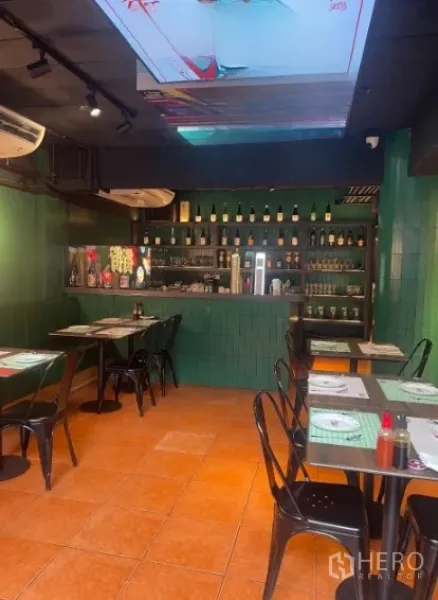 Shophouse for rent in Watthana, Bangkok - Restaurant-style dining area with bar counter, green tiles and set tables.