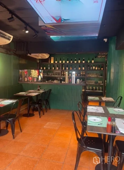 Shophouse for rent in Watthana, Bangkok - Restaurant-style dining area with bar counter, green tiles and set tables.