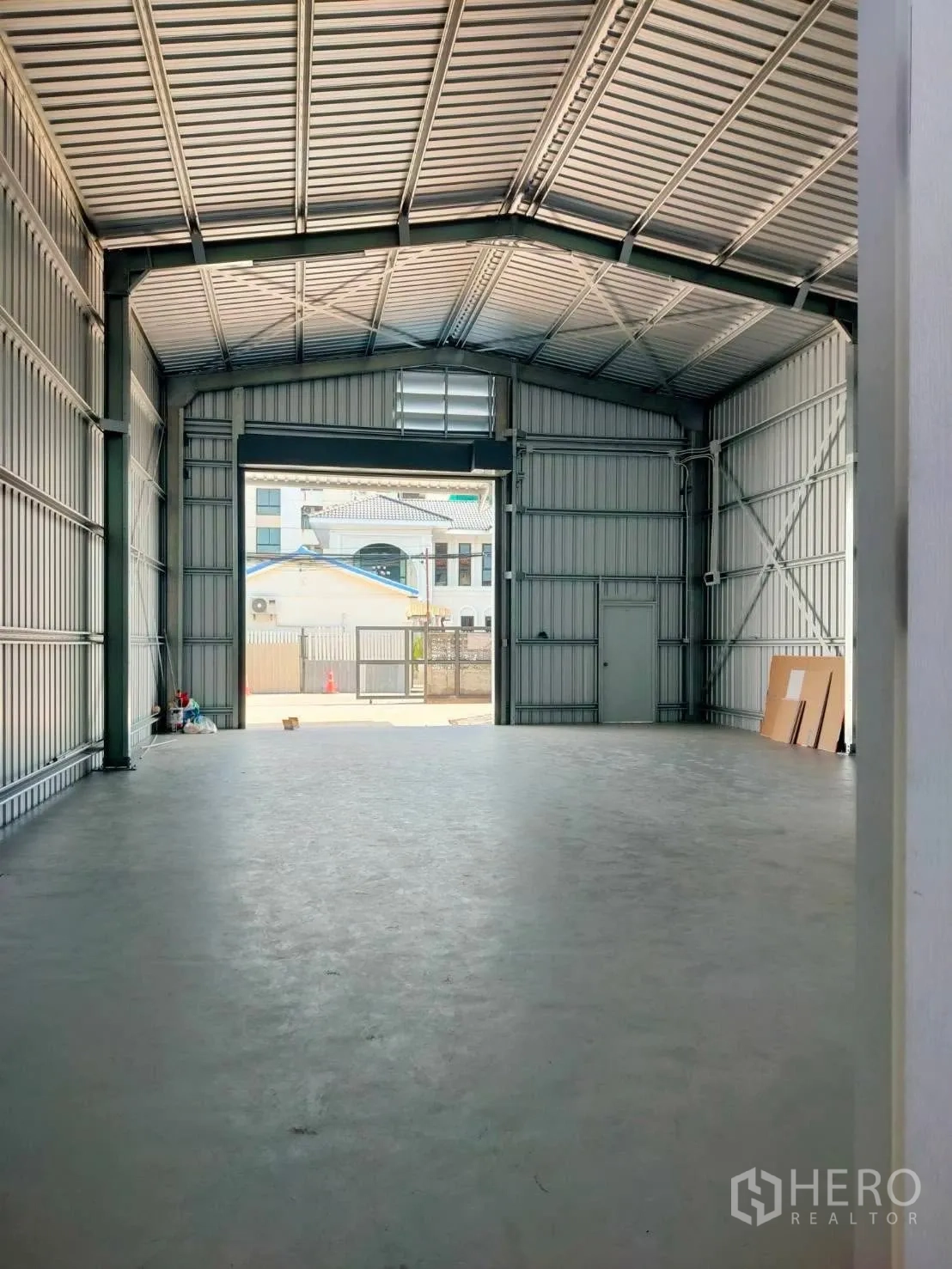 Warehouse for rent in Lat Phrao, Bangkok - Long warehouse bay with high gable roof and wide front entry gate.