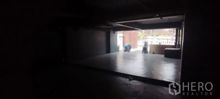 Office Space for rent in Chatuchak, Bangkok - Dim industrial workspace with a raised concrete platform opening to street frontage via roller shutter.