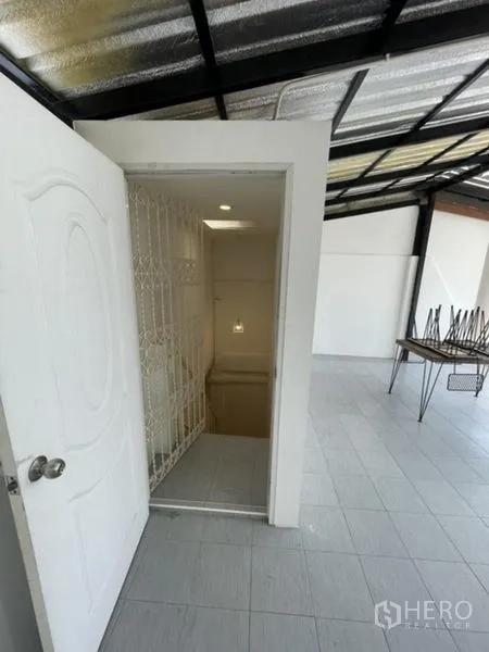 Townhouse for rent in Phra Khanong, Bangkok - Door to the stairwell from the rooftop terrace with a safety gate.