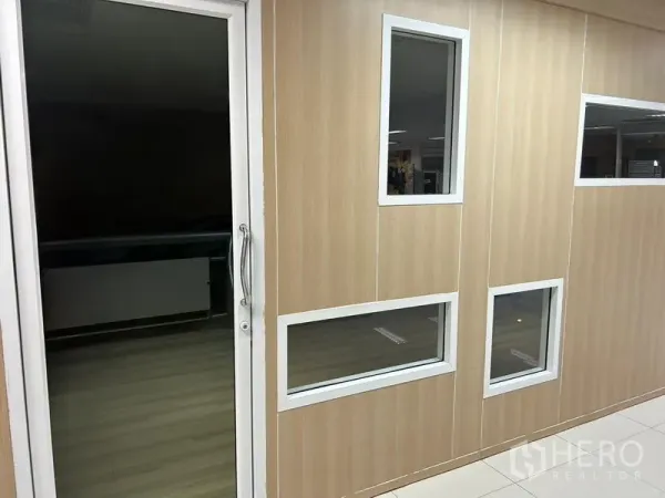 Office Space for rent in Bang Rak, Bangkok - Timber-effect partition wall with white-framed windows and a glass entry door inside the unit.