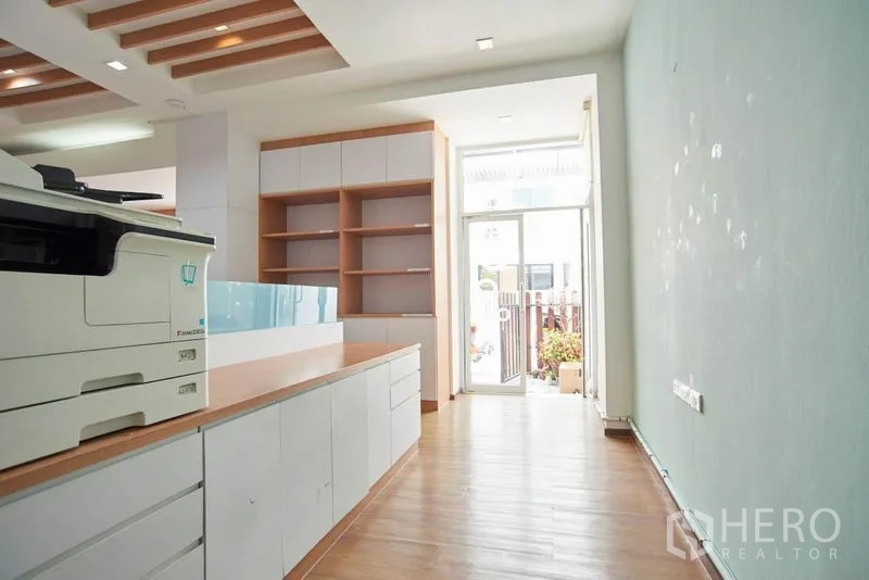 Home Office for rent in Wang Thonglang, Bangkok - Entry corridor leading to a glass door with built-in shelving and printer station.
