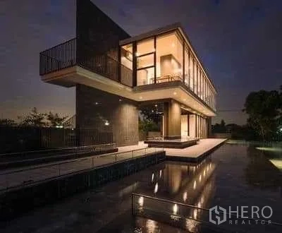 Detached House for rent in Prawet, Bangkok - Clubhouse with reflecting pool at night and a cantilevered upper floor