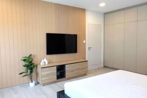 Detached House for rent in Bang Phli, Samut Prakan - Spacious bedroom featuring wood slat accent wall, TV, console and built‑in wardrobes.