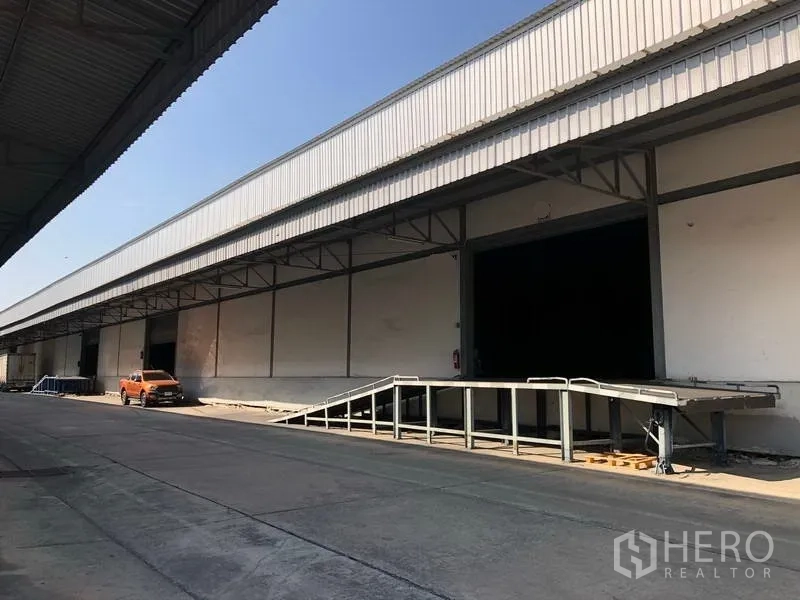 Warehouse for rent in Bang Phli, Samut Prakan - Covered loading dock with ramp for truck access at a warehouse complex.