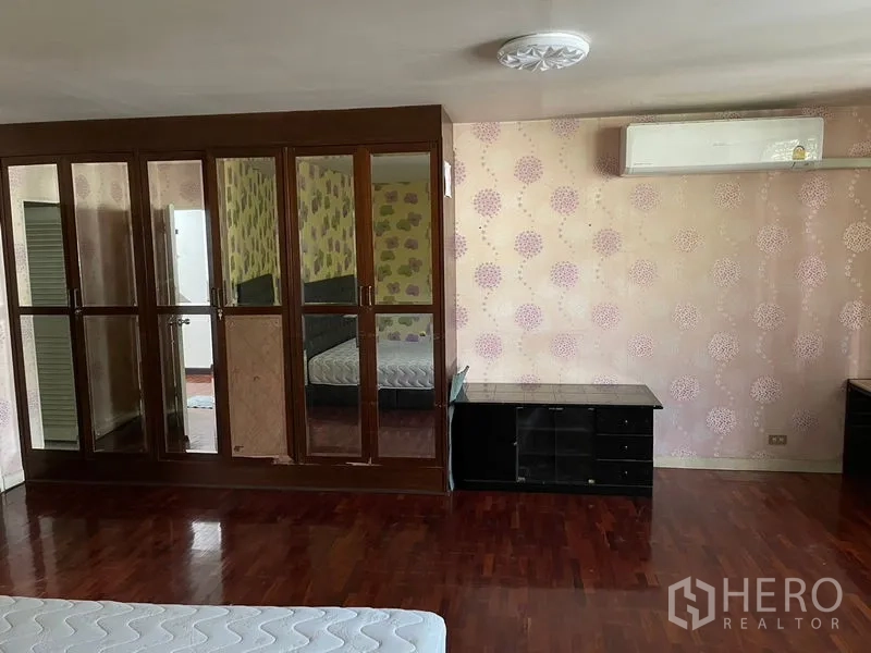 Home Office for rent in Watthana, Bangkok - Spacious bedroom featuring mirrored wardrobe, air conditioner and parquet flooring.
