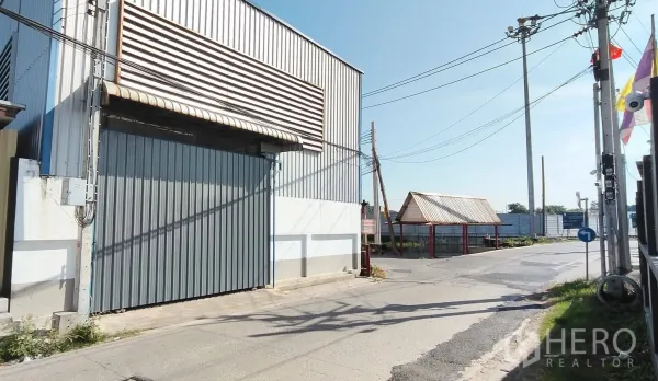 Warehouse for rent in Bang Phli, Samut Prakan - Front entrance of the warehouse with a sliding gate opening to the road.