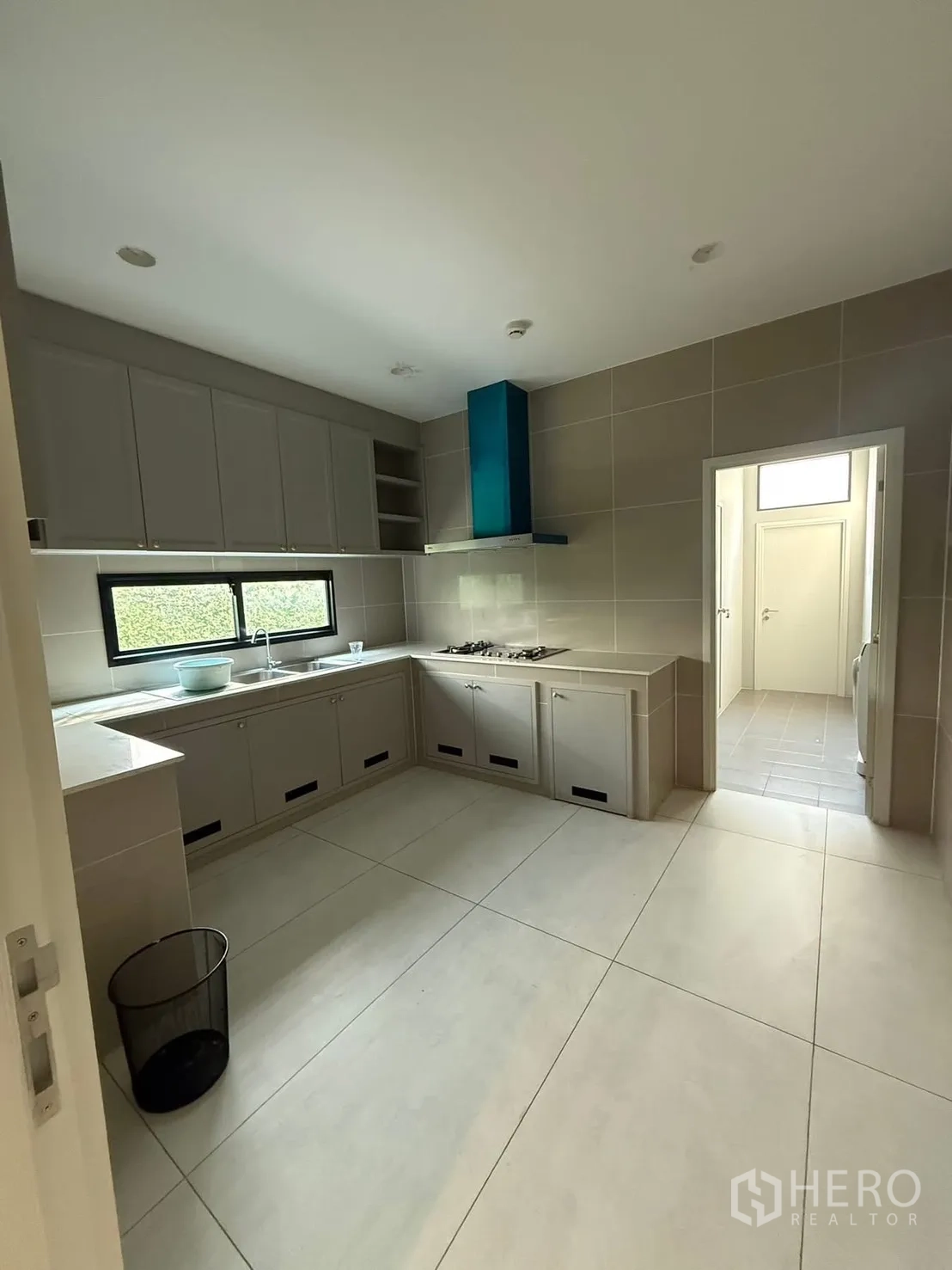 Detached House for rent in Bang Kapi, Bangkok - Separate kitchen with L-shaped cabinetry, gas cooktop and stainless hood.