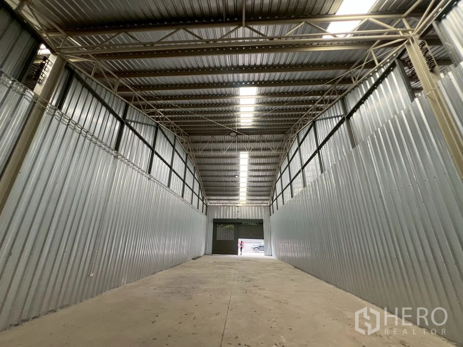 Warehouse for rent in Min Buri, Bangkok - View from the rear toward the roller doors showing long aisle and roof lights.