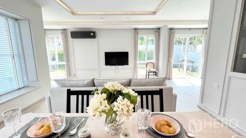 บ้าน ให้เช่าหรือขายในPrawet, Bangkok - มุมโต๊ะทานข้าวมองสู่โซฟาและประตูกระจกเปิดออกสู่สนามหญ้า