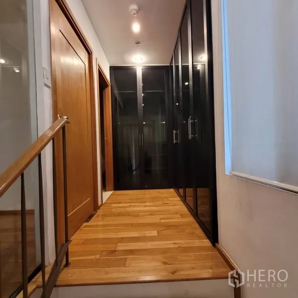 Condominium for rent in Khlong Toei, Bangkok - Upstairs hallway with glass-door wardrobes and wood floors.