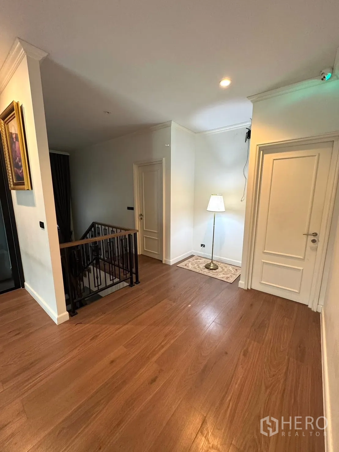 Detached House for sale in Mueang Pathum Thani, Pathum Thani - Second‑floor landing with doors to bedrooms and warm wood floors.