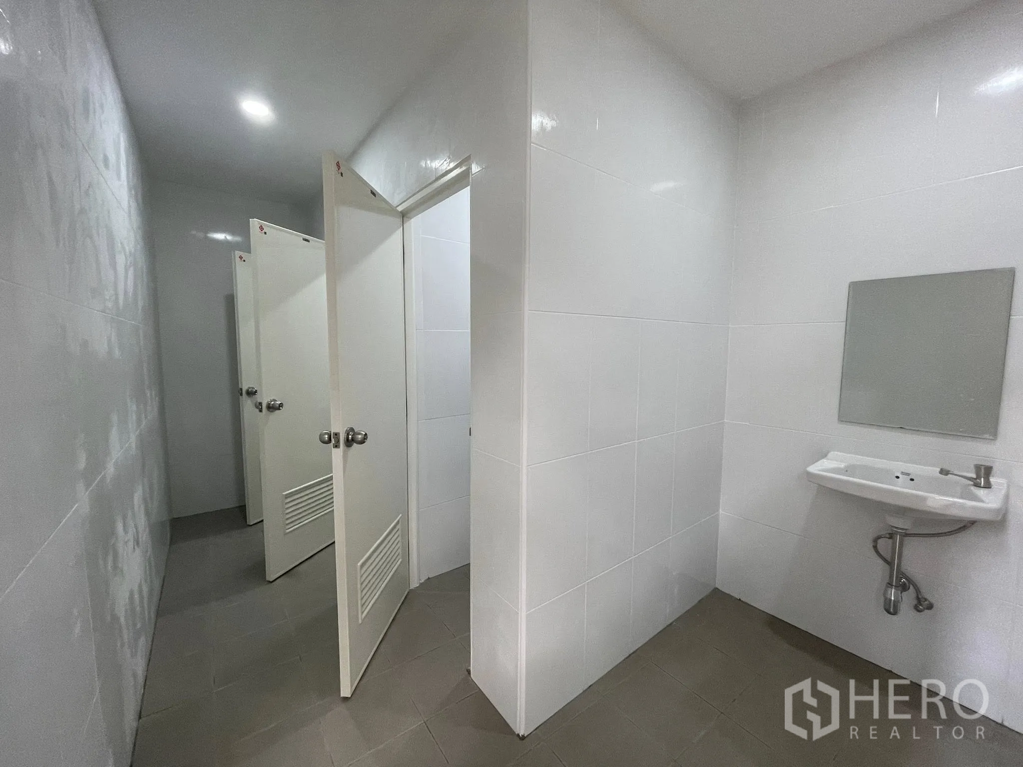 仓库 for rent in Pak Kret, Nonthaburi - 卫生间，瓷砖墙面、洗手盆与隔间门。