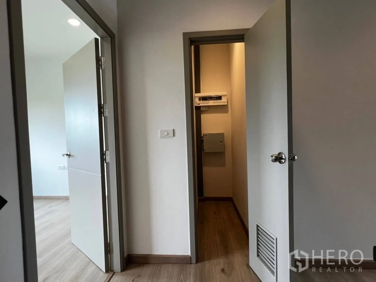 Townhouse for rent in Bang Khen, Bangkok - Upstairs hallway with multiple doors and a compact utility panel closet.