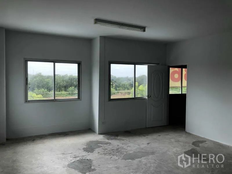 联排别墅 出售在Bang Bua Thong, Nonthaburi - 二层房间，宽大窗户，可见室外绿色景观。
