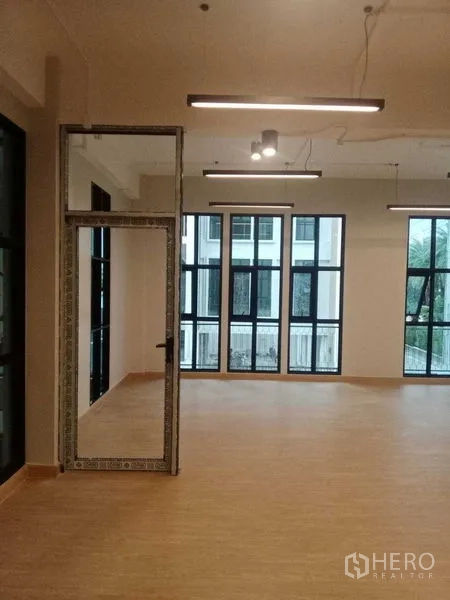 带办公室的家 出租在Bang Kapi, Bangkok - 室内视角：高挑黑框窗与一扇通往相邻空间的玻璃门。