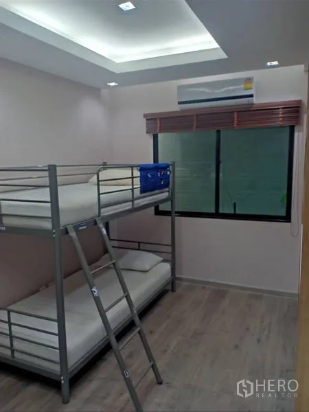 独立式住宅 出租在Thanyaburi, Pathum Thani - 明亮卧室，金属双层床、百叶窗与木纹地板。