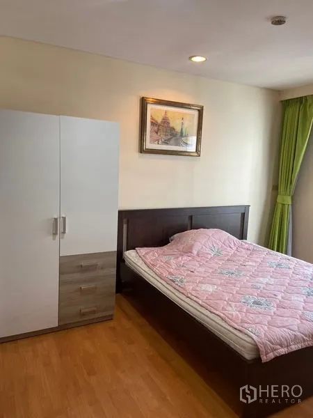 Condominium for rent in Pathum Wan, Bangkok - Second bedroom with double bed, freestanding wardrobe, and green curtains.