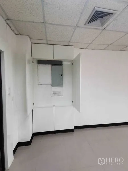 Office Space for rent in Watthana, Bangkok - Electrical panel cabinet and ceiling air vent in a white-walled office corner.