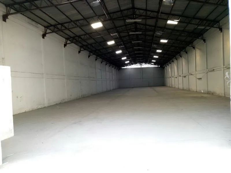 Warehouse for rent in Khlong Toei, Bangkok - Spacious warehouse interior with high steel truss roof, white walls and polished concrete floor lit by skylights.