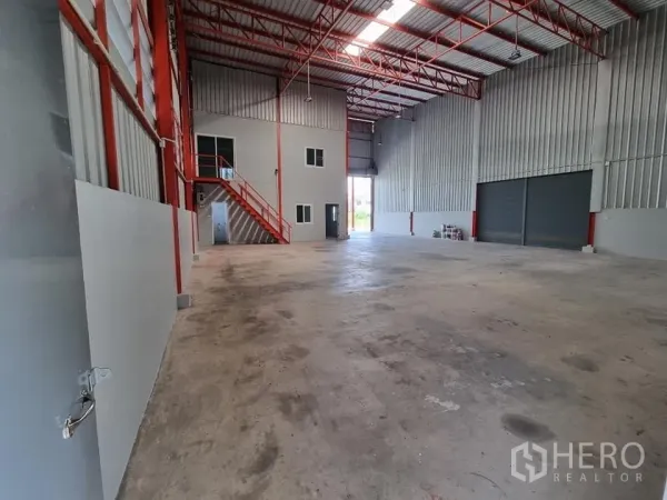 Warehouse for rent in Lam Luk Ka, Pathum Thani - Spacious warehouse interior with high clear height, red steel trusses and twin roller shutter doors.