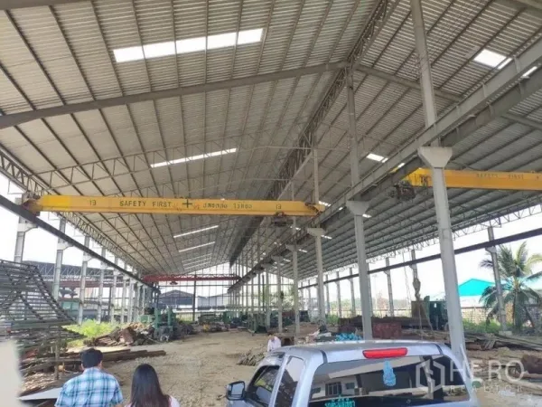 Factory for rent in Samut Sakhon - Wide-span warehouse interior featuring twin yellow cranes and roof skylights in Samut Sakhon.