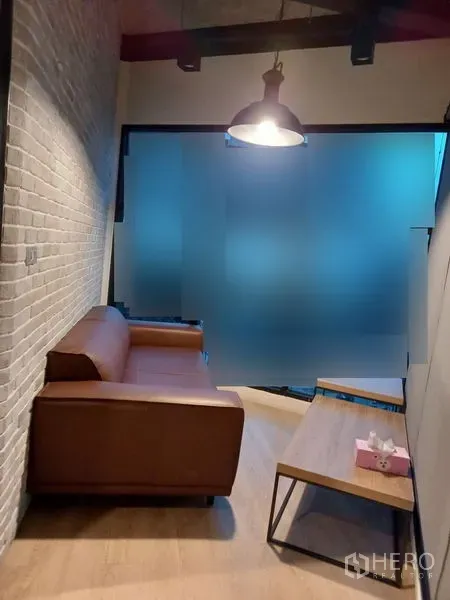 Office Space for rent in Chatuchak, Bangkok - Small lounge with brown sofa, coffee table and frosted glass partition.