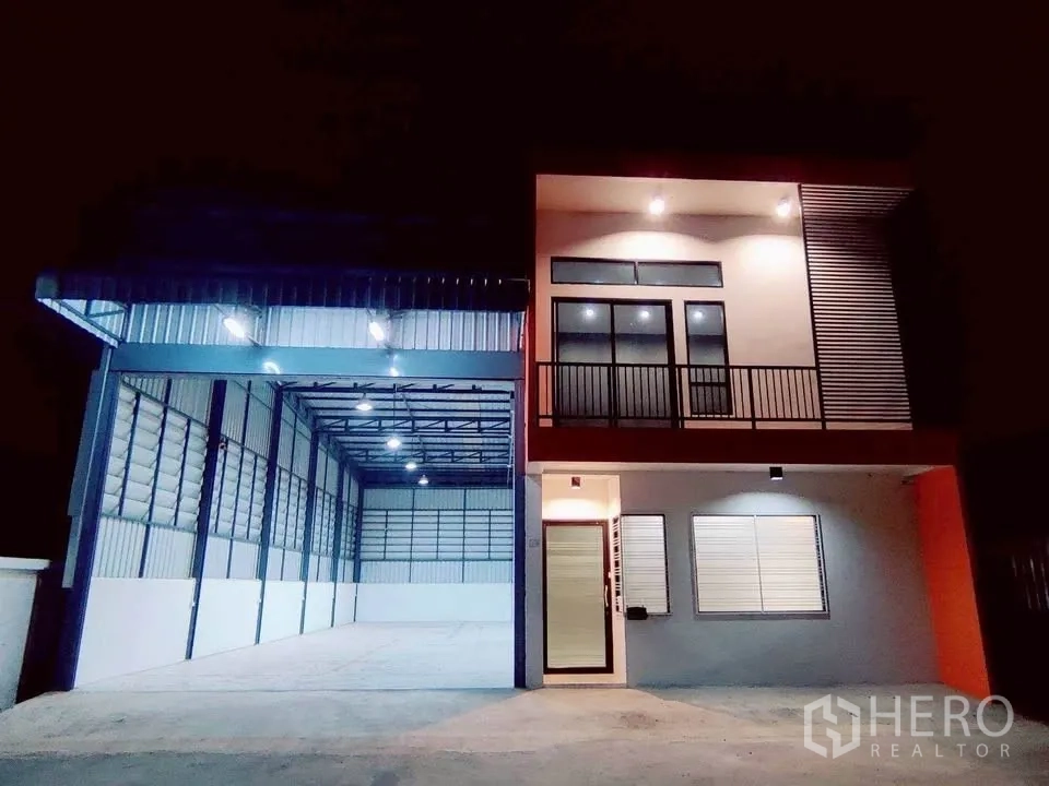 Warehouse for rent in Lam Luk Ka, Pathum Thani - Well-lit warehouse and office facade at night with covered loading zone.