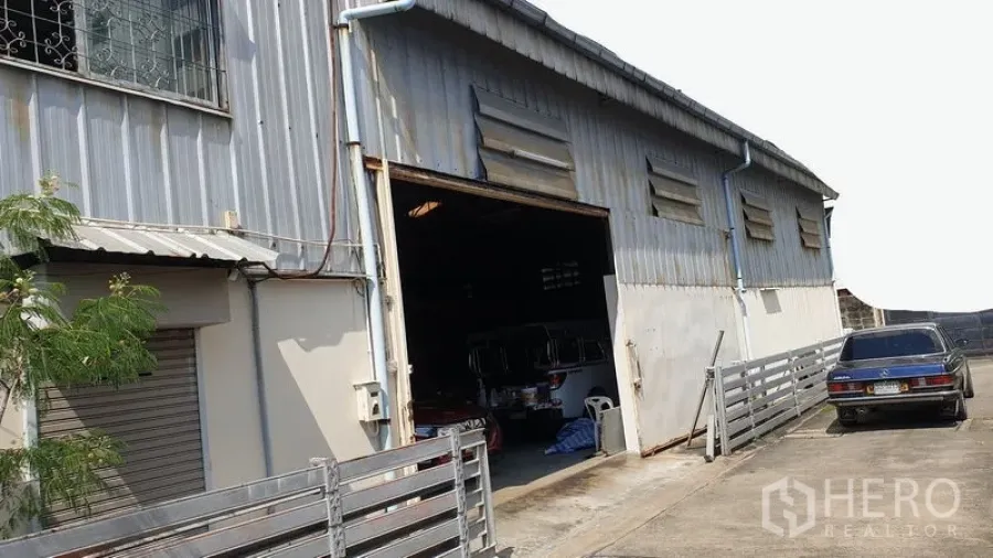 Warehouse for rent in Suan Luang, Bangkok - Metal‑clad warehouse exterior with large sliding door and driveway parking.