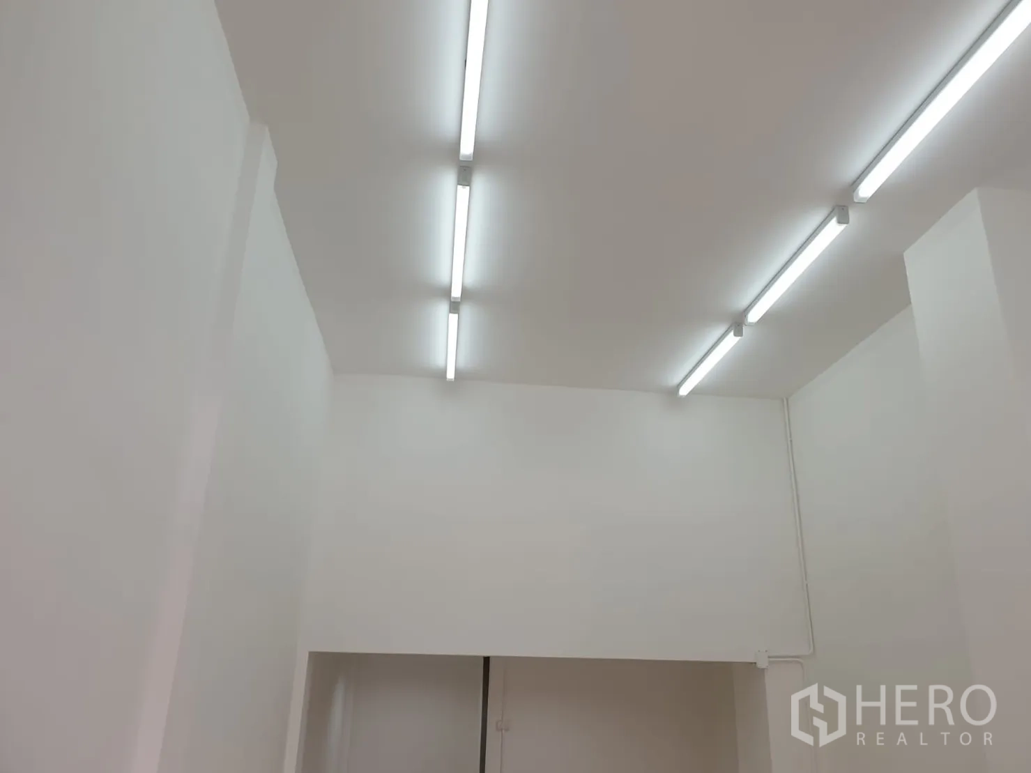 Shophouse for rent in Khlong Toei, Bangkok - Bright white interior of shophouse showing high ceiling with linear LED lights.