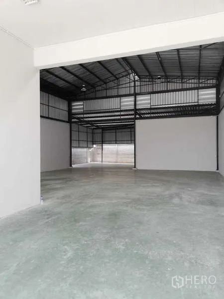 Factory for rent or sale in Ban Phaeo, Samut Sakhon - High-ceiling warehouse interior with steel trusses and smooth concrete floor