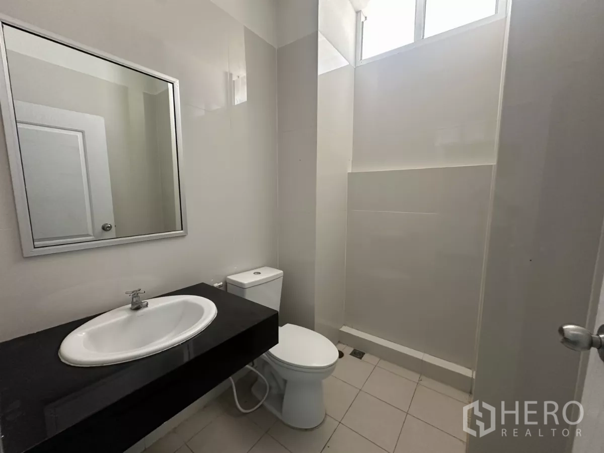 Factory for rent in Bang Phli, Samut Prakan - Second restroom featuring sink, toilet and a shower area with light tiles.