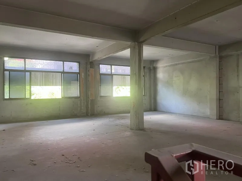 Shophouse for rent in Watthana, Bangkok - Bright open workspace with corner windows and structural concrete columns.
