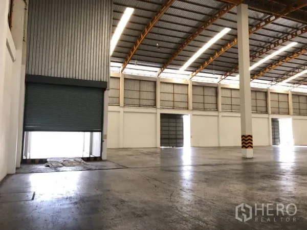 Warehouse for rent in Phra Nakhon Si Ayutthaya - Roller shutter door opening to an elevated loading bay inside the warehouse.