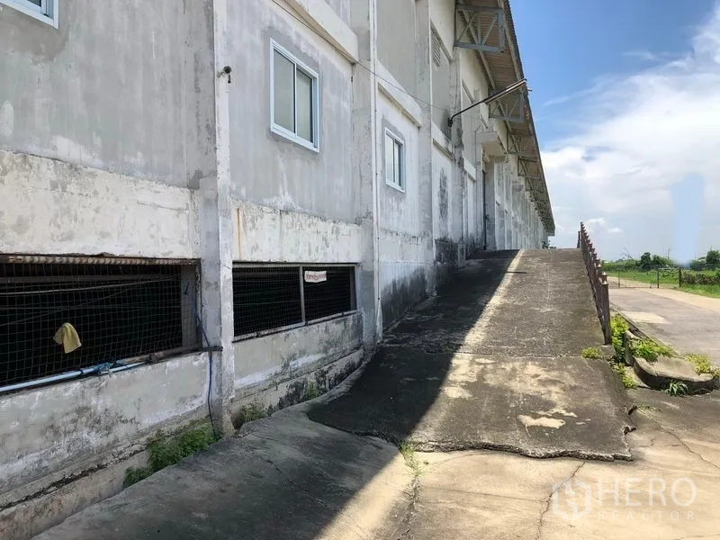 Factory for rent in Lat Krabang, Bangkok - Concrete ramp leading to an elevated loading bay beside the factory facade.