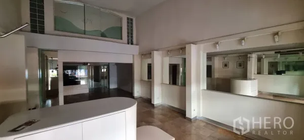Shophouse for rent or sale in Bangkok - Ground-floor retail space with reception counter, mirrors and a mezzanine glass panel.