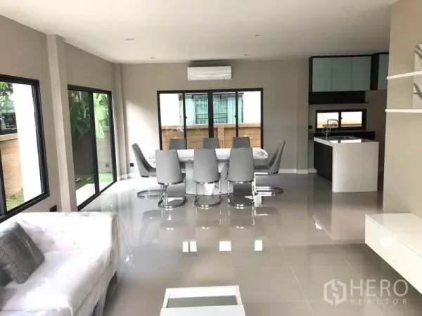 Detached House for rent in Saphan Sung, Bangkok - Bright open-plan space with full-height windows, dining set and views to the garden.